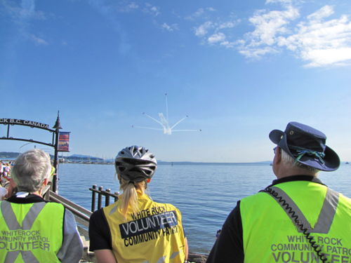 Photo of three volunteers conducting crowd control at a community event.