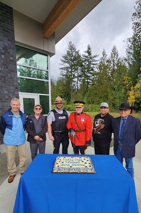 Picture of Village of Gold River Mayor Michael Lott, Village of Tahsis Mayor Martin Davis, Nootka Sound Detachment Commander Sergeant Greg Young, Mowachaht Muchalaht First Nation Chief Nathan George and Chief Jerry Jack, and BC RCMP Commanding Officer Deputy Commissioner Dwayne McDonald cutting the ceremonial cake.