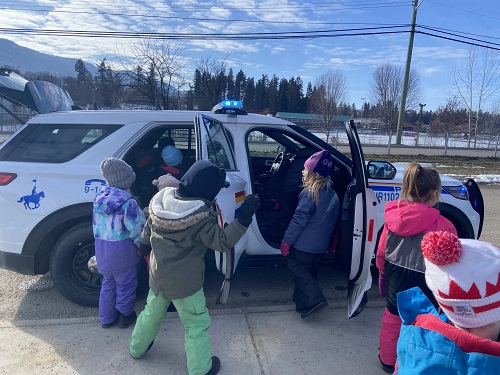 Children examining a police car.